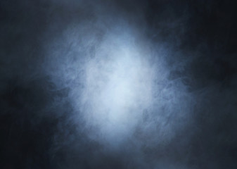 Colorful smoke on a dark background with light in the center