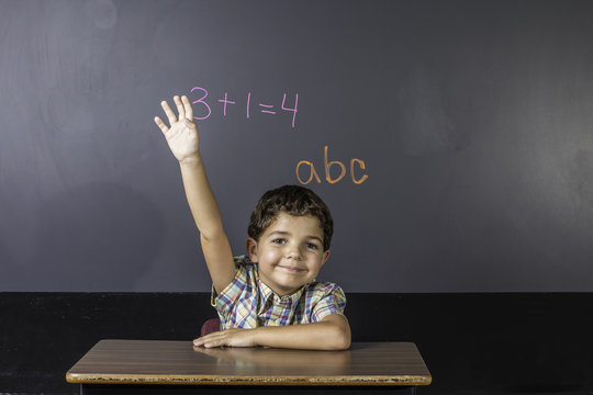 Child Raising Hand In Classroom.