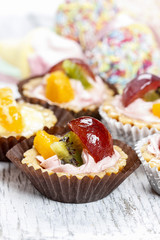 Cupcake with fresh fruits. Diversity of sweets in the background