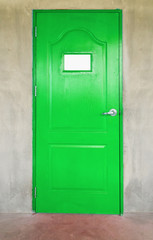 Wooden green door in concrete wall