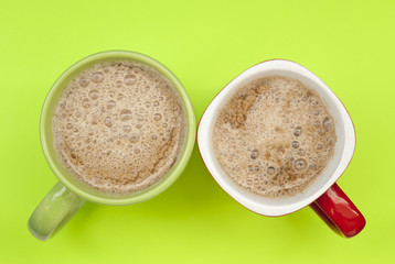 Two cups of coffee on a green background