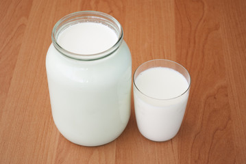 Obraz na płótnie Canvas Glass jar and a glass of milk on table