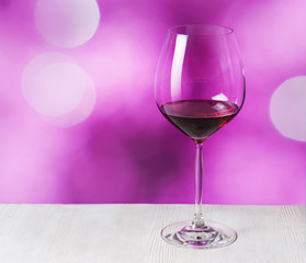 Glass of red wine on purple background