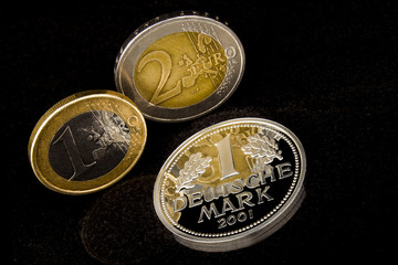Euro und Deutsche Mark auf schwarzem Hintergrund