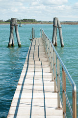 small bridge over blue laguna water in Venice