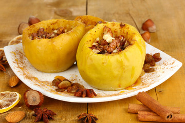 Baked apples on plate on wooden table