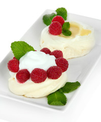 Tasty meringue cakes with berries, isolated on white