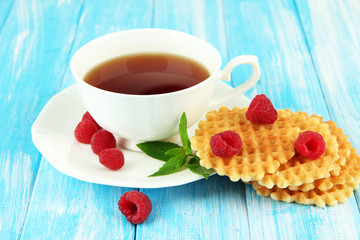 Cup of tea with cookies and raspberries on table close-up