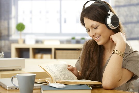 Happy woman with book and headphones