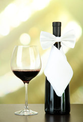 White bow tie on wine bottle on bright background