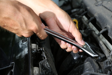 Hand with wrench. Auto mechanic in car repair