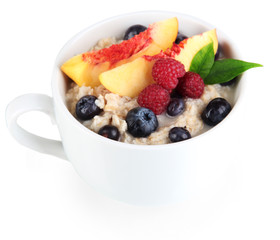 Oatmeal in cup with berries isolated on white