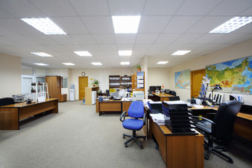 Light and spacious office with work desks, computers and map.