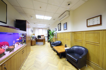 Light office with leather armchairs and aquarium