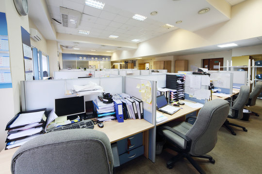 Empty places of work separated by partition with desk, computers