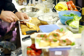 Male chefs hands make delicious sandwich on table