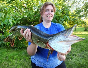 Successful angler woman with a big Northern Pike.