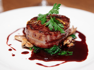 Tenderloin steak wrapped in bacon with red sauce