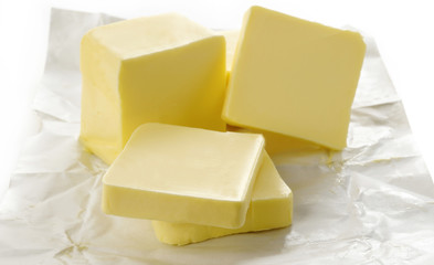 Piece of butter in paper on white background