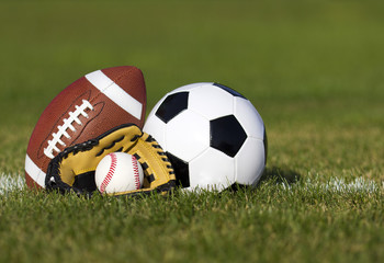 Soccer ball, American football and Baseball in yellow glove