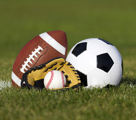 Soccer ball, American football and Baseball in glove
