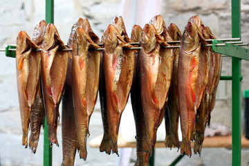 Räucherfisch Forelle hängt auf Stange