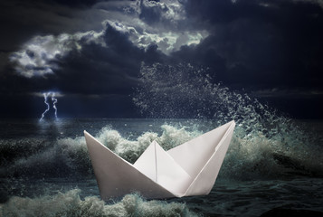 paper ship in storm concept