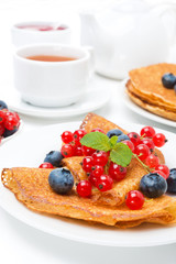 Breakfast with pancakes, fresh berries and black tea