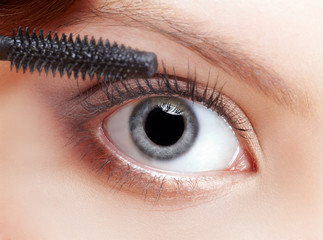 Obraz premium beautiful woman applying mascara