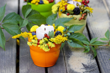Fototapeta na wymiar Candle holder decorated with autumn flowers and other plants