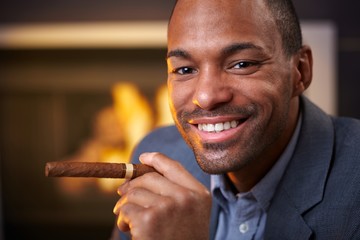 Happy ethnic man smoking cigar