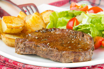 Grilled meat beef with golden potatoes and fresh salad