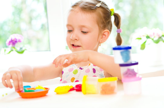 child is playing with colorful dough