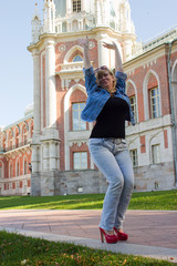 A woman in a blue jacket walking near the Tsaritsyno palace in t