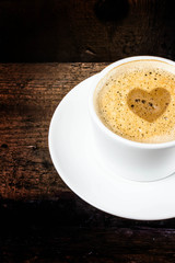 Closeup cup of espresso on old wooden table over grunge backgrou