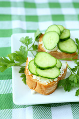 bruschetta with cheese and fresh cucumber on a plate