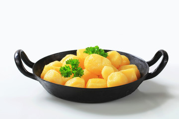 Cooked potatoes on a black pan