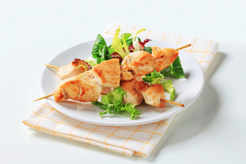 Chicken skewers and salad greens