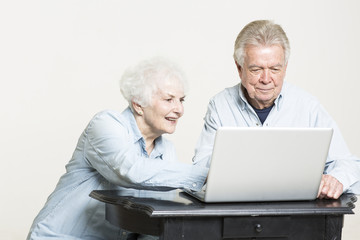 Senior couple is looking at computer screen