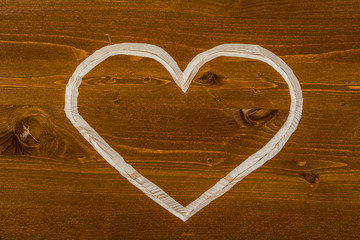Сarved heart on orange wood background