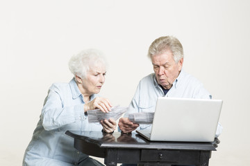 Senior couple is looking at the bills concerned
