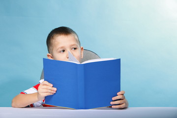 child boy kid reading a book on blue