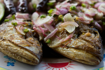 Close-up of fried salted mackerel topped with chili