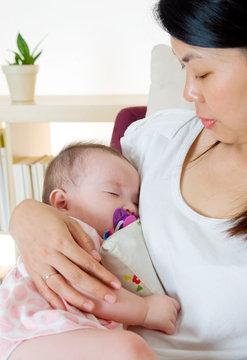 Asian Mother Holding Her Sleeping Baby