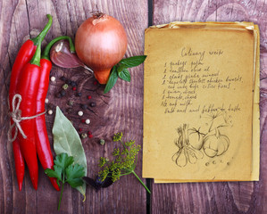 Spices and old recipe book on wooden background.