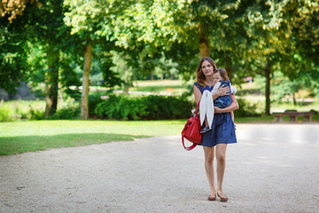 Fototapeta na wymiar Beautiful mother and little daughter walking in summer park