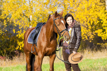 equestrian with her horse in autumnal nature