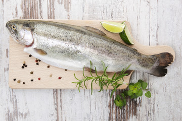Trout on wooden kitchen board.