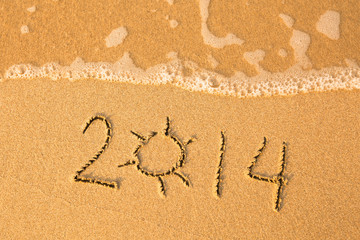 2014 written in sand on beach texture, soft wave of the sea.