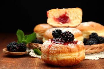 Tasty donuts with berries on wooden table